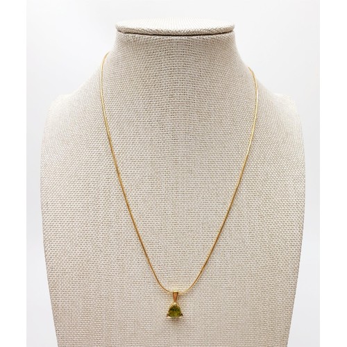 23 - A 14ct gold peridot set pendant on a 14ct gold chain, gross weight 5.7g, chain length 16