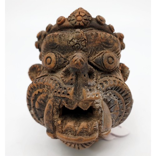 17 - An antique terracotta statue head depicting the Tibetan/Nepalese deity Mahakala, height 2.75