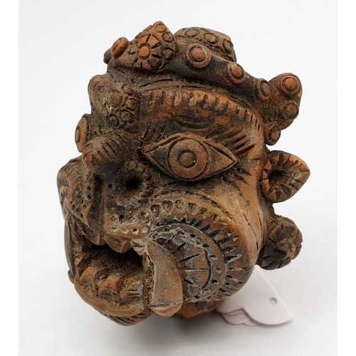 17 - An antique terracotta statue head depicting the Tibetan/Nepalese deity Mahakala, height 2.75