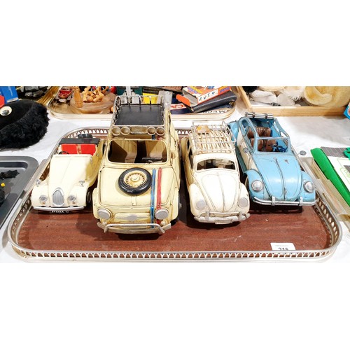 215 - Two tin plate Beetle models, a tin plate Fiat 500 model and one other model car. UK shipping £14.