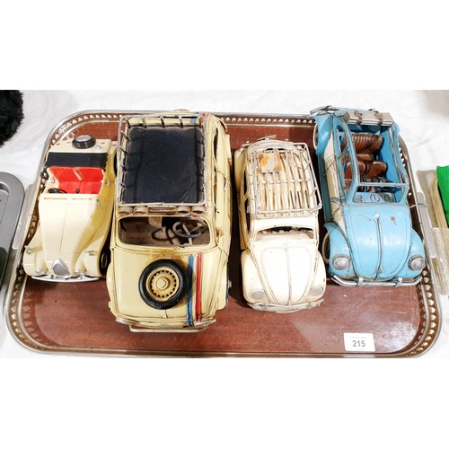 215 - Two tin plate Beetle models, a tin plate Fiat 500 model and one other model car. UK shipping £14.