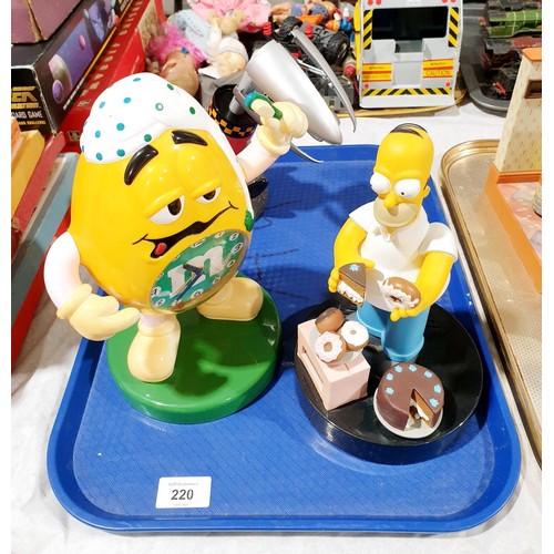 220 - A Simpson's alarm clock, an M&Ms alarm clock which is A/F, and a rocket desk lamp. No shipping. Arra... 