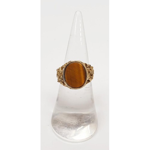 20 - A yellow metal ring set with tigers eye, gross weight 3.7g, size K. UK shipping £14.