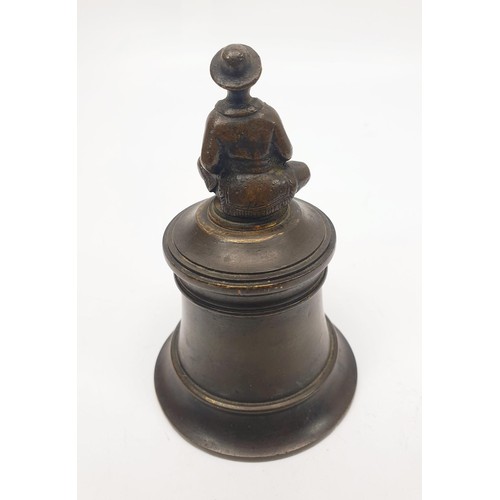 61 - An antique bronze bell, the handle formed as a China man, replacement clapper, height 4