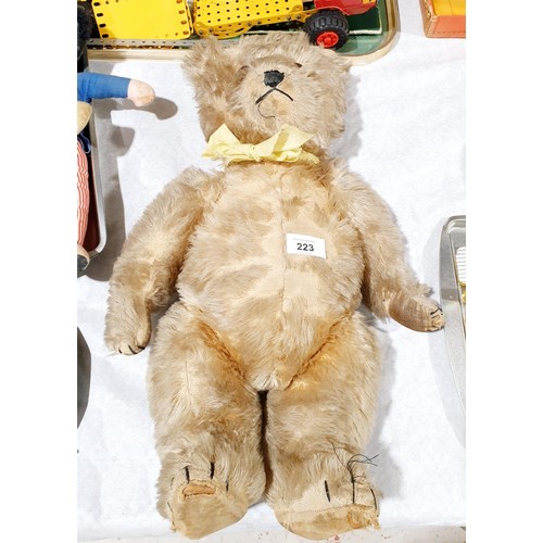 223 - A vintage straw filled articulated teddy bear, length 19.5