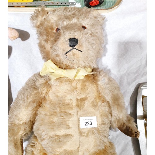 223 - A vintage straw filled articulated teddy bear, length 19.5