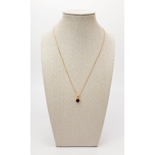 21 - An 18ct gold pendant set with a red stone on a 9ct gold chain, chain length 18