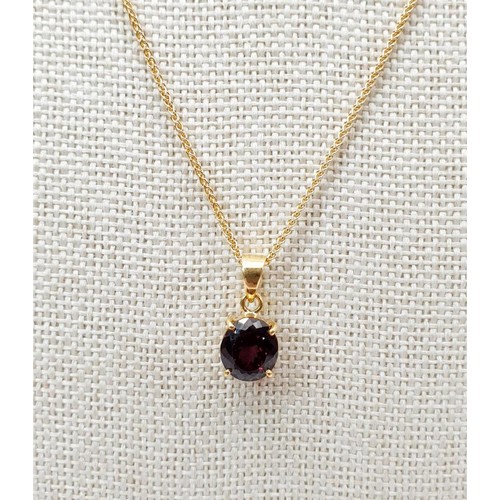 21 - An 18ct gold pendant set with a red stone on a 9ct gold chain, chain length 18