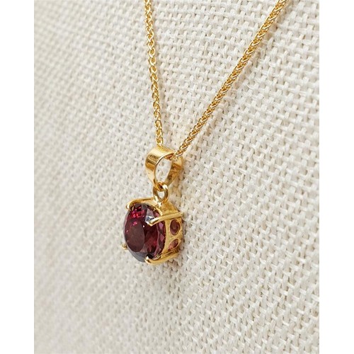 21 - An 18ct gold pendant set with a red stone on a 9ct gold chain, chain length 18