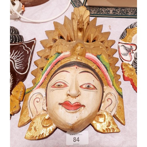 84 - A carved wooden wall mask depicting an eastern deity, length 12