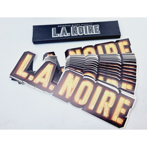 201 - LA Noire promotional items: a boxed N473-3-1B flashlight, a pack of pencils and twenty stickers. UK ... 