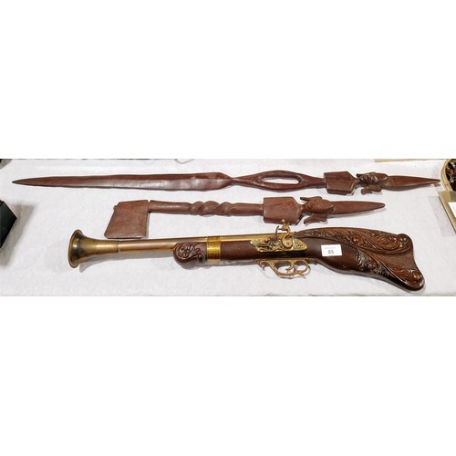 85 - A reproduction decorative blunderbuss, length 68.5cm together with two wooden tribal style carvings ... 