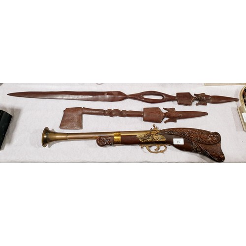 85 - A reproduction decorative blunderbuss, length 68.5cm together with two wooden tribal style carvings ... 