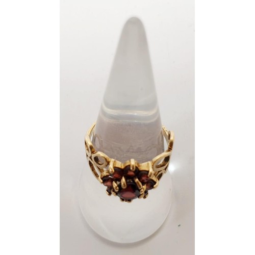 58 - A hallmarked 9ct gold red stone daisy cluster ring, gross weight 2.9g, size N/O. UK shipping £14.