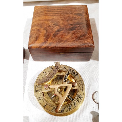 59 - A brass sundial in a wooden case, one smaller sundial, a compass and a compass with label 