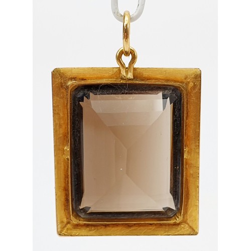 43 - A smokey quartz in a yellow metal pendant mount, A/F, length 4cm. UK shipping £14.