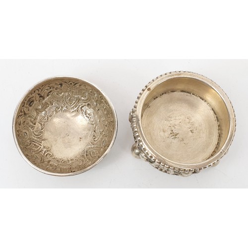 57 - Two far eastern white metal condiment type bowls each embossed with deities and foliage, the largest... 