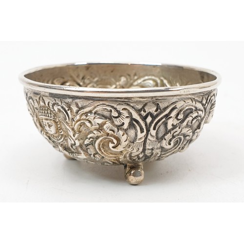 57 - Two far eastern white metal condiment type bowls each embossed with deities and foliage, the largest... 