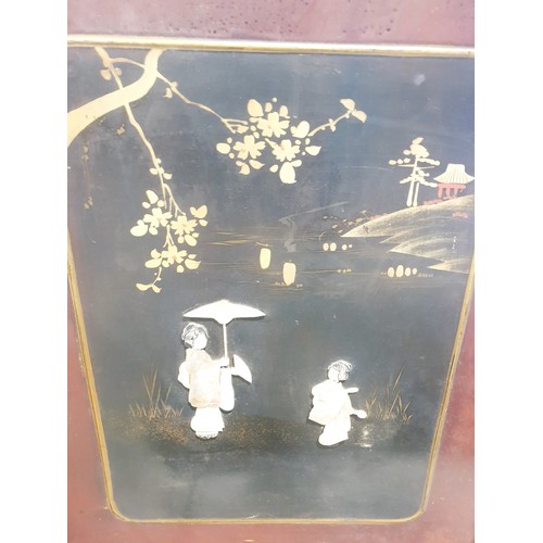 198 - A vintage Japanese carved wooden two leaf screen decorated with relief figures of mother of pearl an... 