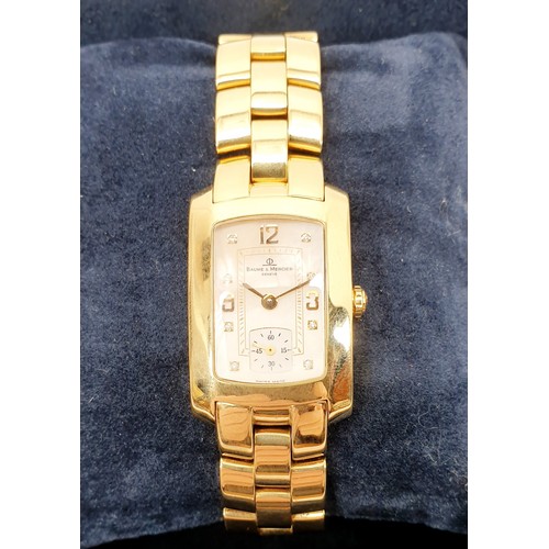 8 - A ladies boxed 18ct gold Baume & Mercier quartz wrist watch, on an 18ct gold bracelet, having a cham... 