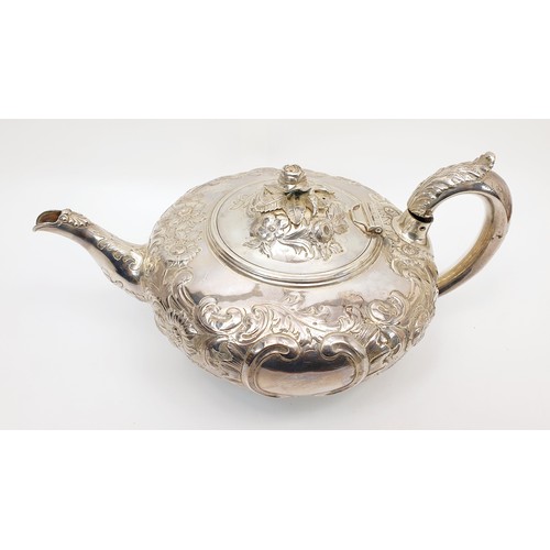 31 - A Victorian hallmarked silver teapot of squat form, heavily embossed with Rococo decoration and a fl... 