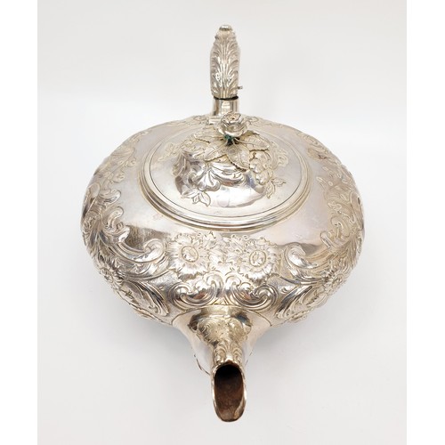 31 - A Victorian hallmarked silver teapot of squat form, heavily embossed with Rococo decoration and a fl... 