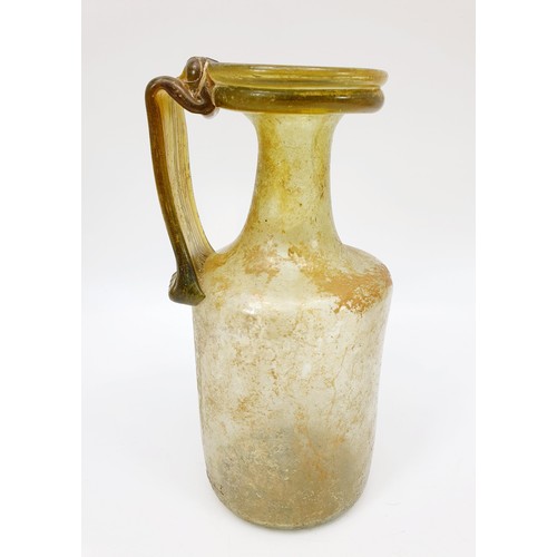 40 - Antiquities: a Roman green glass jug with label to base from the J. R. Preece Collection, height 18c... 