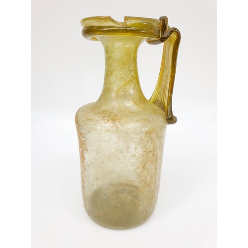 40 - Antiquities: a Roman green glass jug with label to base from the J. R. Preece Collection, height 18c... 