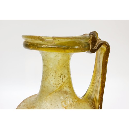 40 - Antiquities: a Roman green glass jug with label to base from the J. R. Preece Collection, height 18c... 