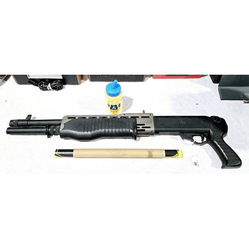 20 - A spring powered plastic BB gun, length 77cm. No shipping. Arrange collection or your own packer and... 