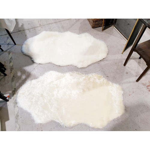 128 - Two new synthetic sheepskin style rugs, length 140cm. UK shipping £14.