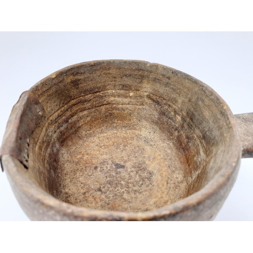 30 - An ancient clay pot with grooved markings inside the bowl and a metal repair, diameter 117cm. No shi... 