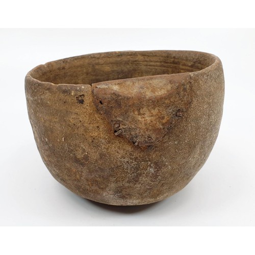 30 - An ancient clay pot with grooved markings inside the bowl and a metal repair, diameter 117cm. No shi... 