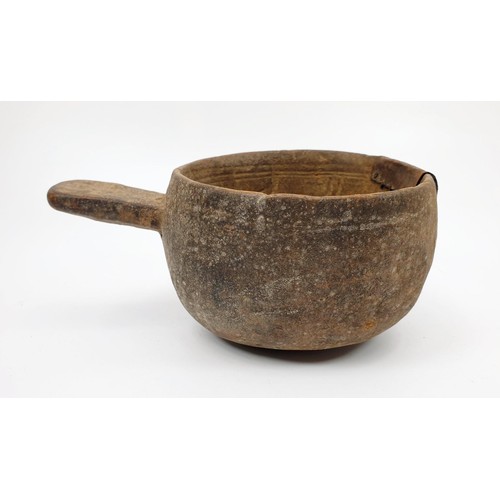 30 - An ancient clay pot with grooved markings inside the bowl and a metal repair, diameter 117cm. No shi... 