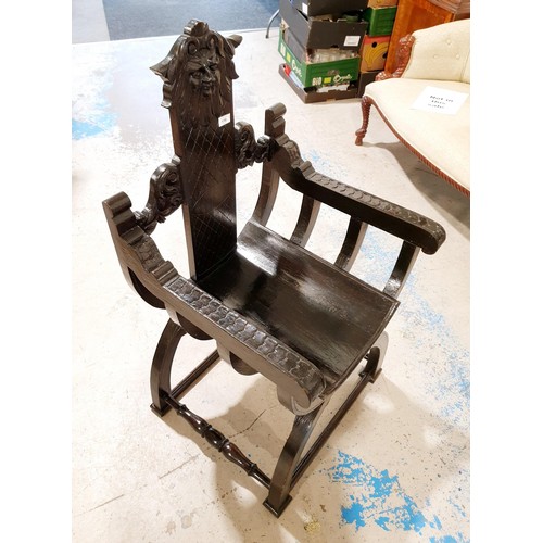 116 - An antique Savonarola oak arm chair in the Italian style, the splat carved with lattice and topped w... 