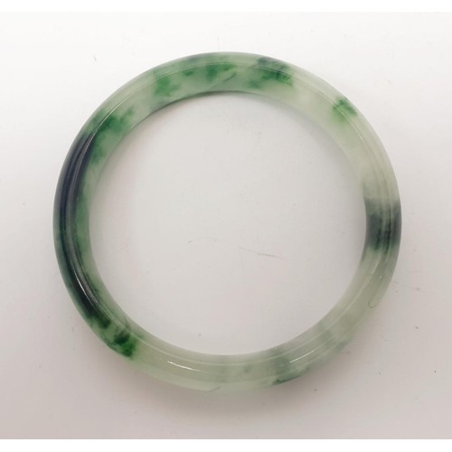 30 - A treated jade bangle, internal diameter 5.5cm. UK shipping £14.