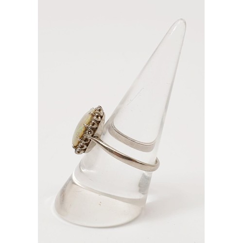 4 - A white metal ring set with an opal and diamond, size Q/R, gross weight 3.3g. UK shipping £14.