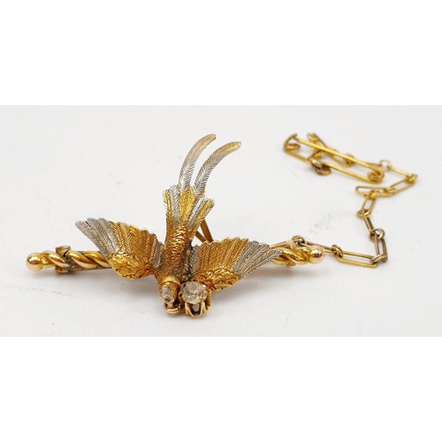 26A - A yellow and white metal brooch in the form of a pheasant in flight having a collar with a diamond s... 