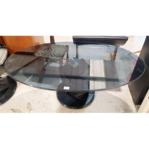 134 - A smokey glass spiral oval coffee table, width 120cm together with two matching circular tables, dia... 