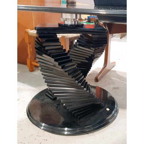 134 - A smokey glass spiral oval coffee table, width 120cm together with two matching circular tables, dia... 