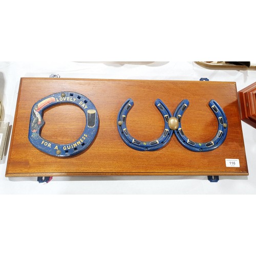 116 - Three horseshoes with Guinness advertising painted on them mounted on a wall plaque, width 65.5cm to... 