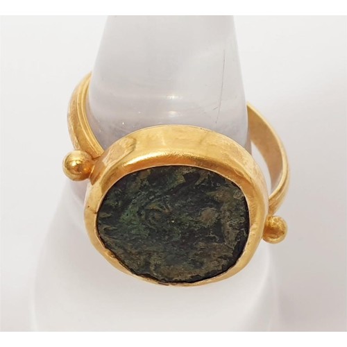 10 - A 14ct gold ring set with an ancient Greek bronze coin, gross weight 6.12g, size O. In house shippin... 
