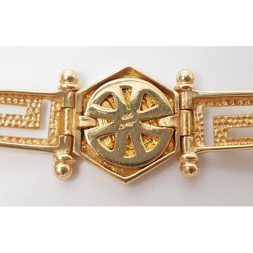 12 - A 14ct gold Greek key motif bracelet, with a central captive gold coin and two coral cabochons, leng... 