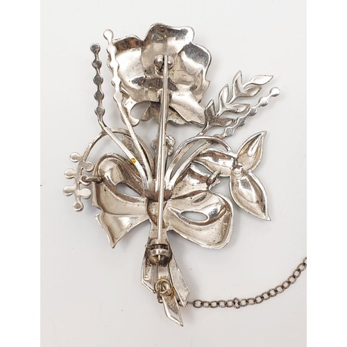 23 - A white metal and enamel brooch in the form of a flower set with marcasite A/F, gross weight 23g. In... 