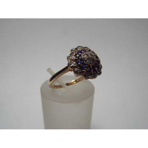 61 - 9ct Gold Diamond & Sapphire ring set in flower pattern.  2.8g Fomger size 'R'  IIV of £350