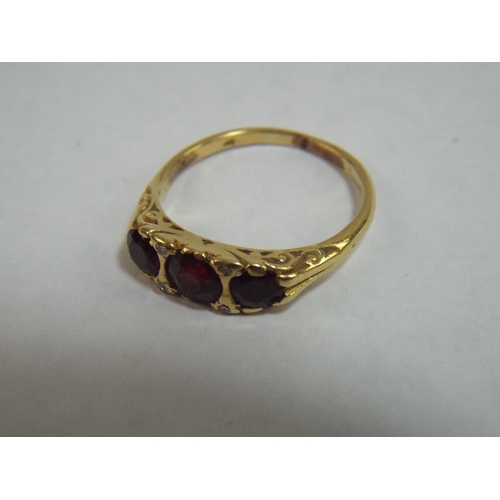 36 - 18 Ct Gold Ring set with Three Garnets and Diamonds. Hallmarks Rubbed but tested 18ct. 4.8g 'P'