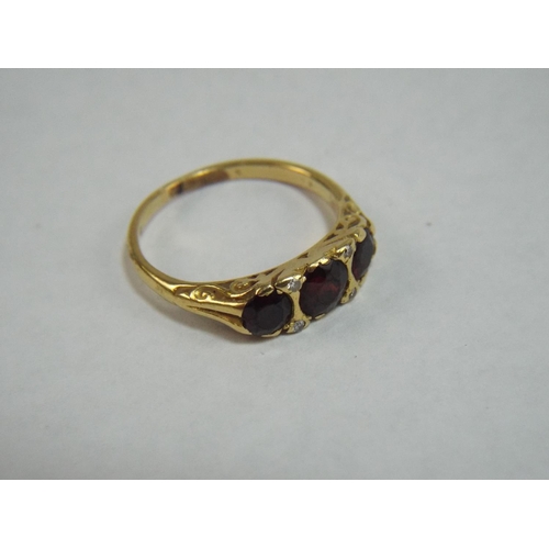 36 - 18 Ct Gold Ring set with Three Garnets and Diamonds. Hallmarks Rubbed but tested 18ct. 4.8g 'P'