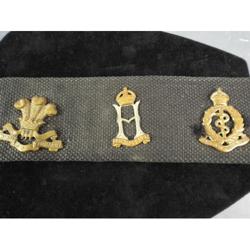 12 - A Navy Webbing Belt with 14 Regimental Cap badges attached.. WW1 MGC badge not original