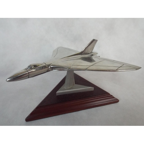 107 - A solid Pewter model of a Vulcan Bomber on wooden plinth & original box. 4.5 inch wingspan