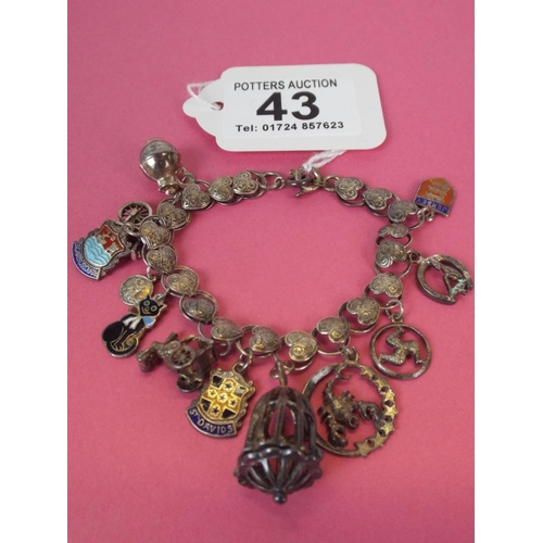 43 - 925 Silver charm bracelet with silver and enamel charms.  27.3g